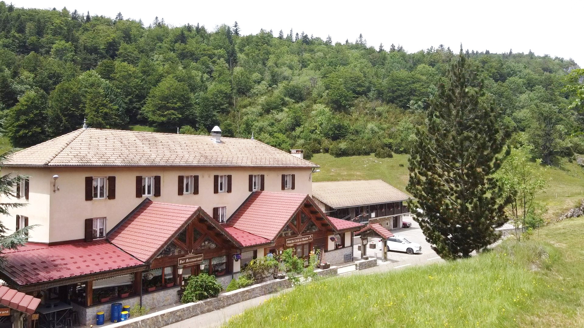 Façade principale intégrant le restaurant et les hébergements implantée au cœur d’un environnement naturel