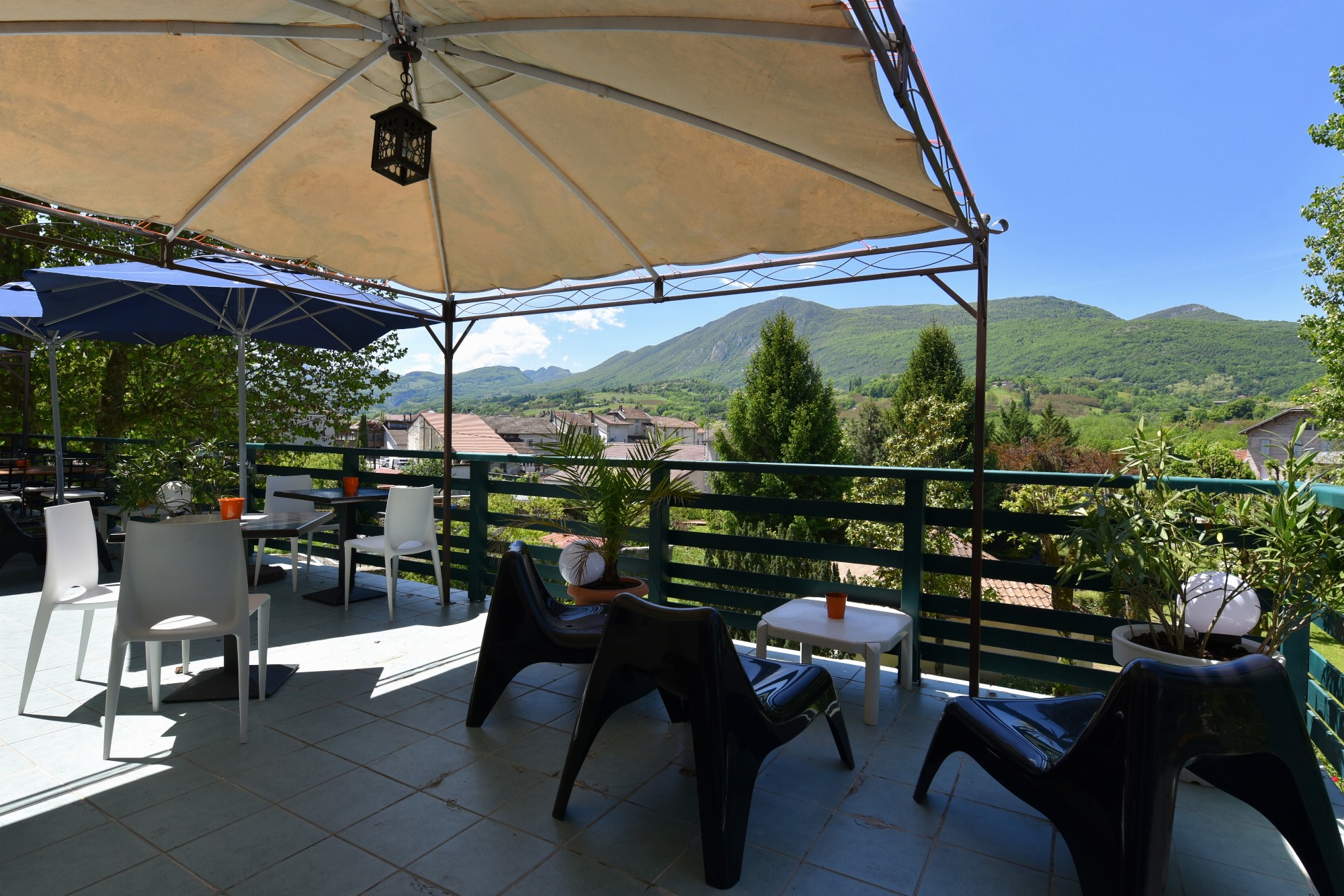 Trois tables accompagnées de leurs chaises vous accueillent pour un moment de détente à l’ombre d’une pergola