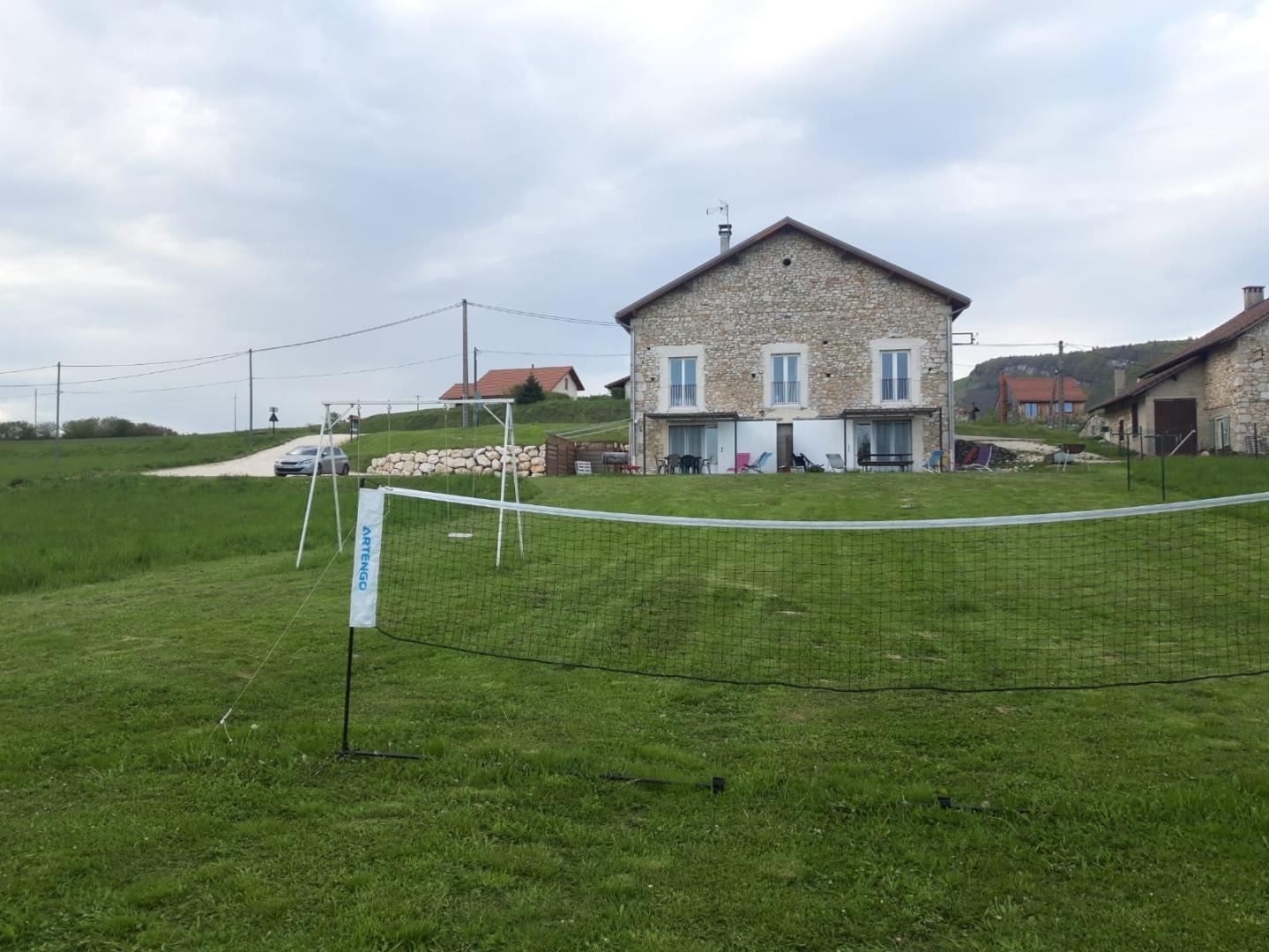 Le gîte vue depuis le champ : balançoire, filet de volley