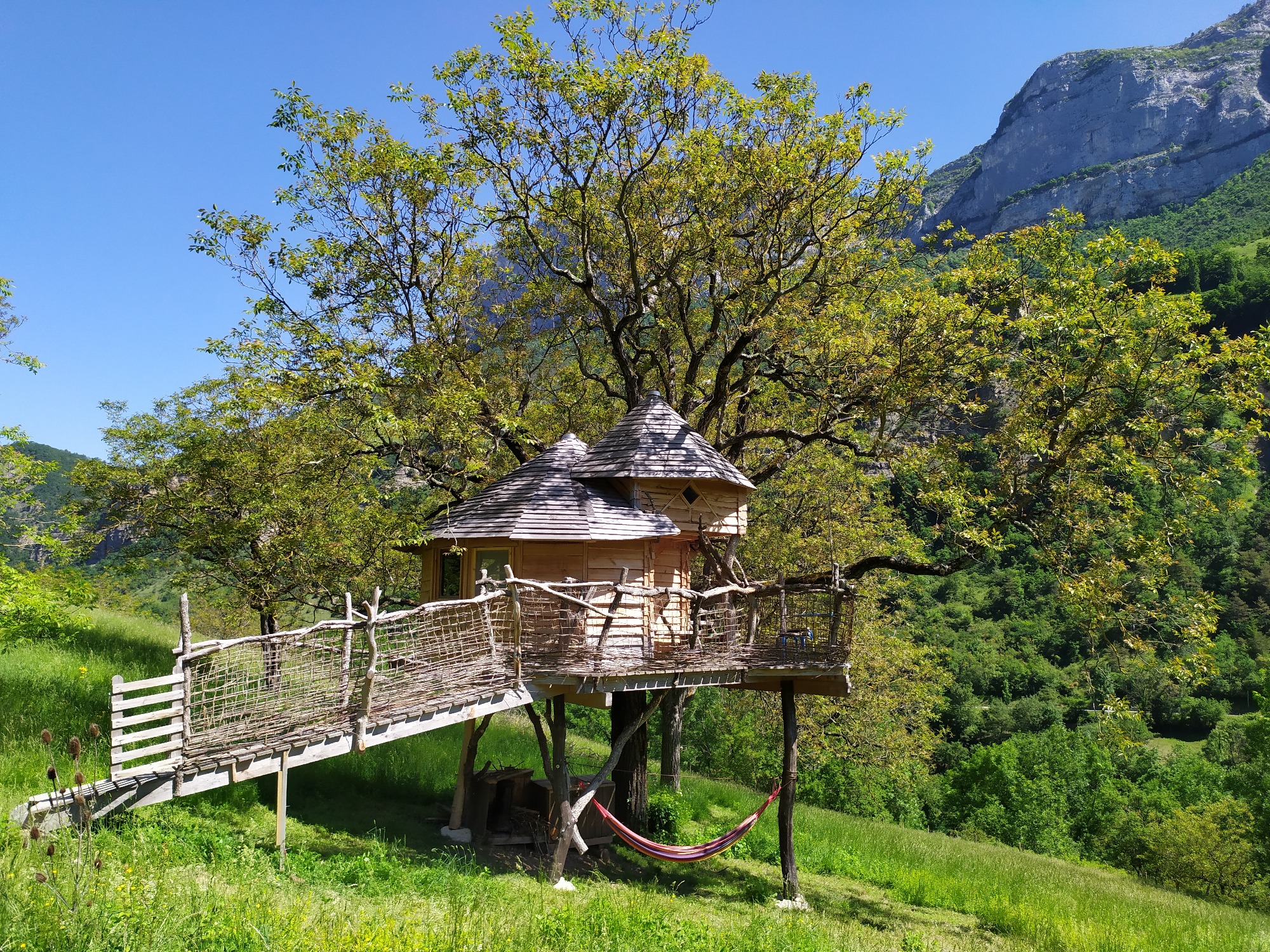 Vue Cabane La Bicoque au milieu d'un champ adossé aux falaises du Vercors
