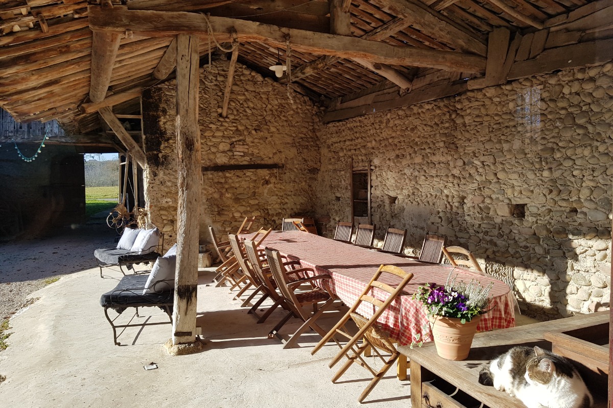 Sous le préau, la grande table extérieure mais protégée du soleil et de la pluie pour partager l'apéritif ou les repas