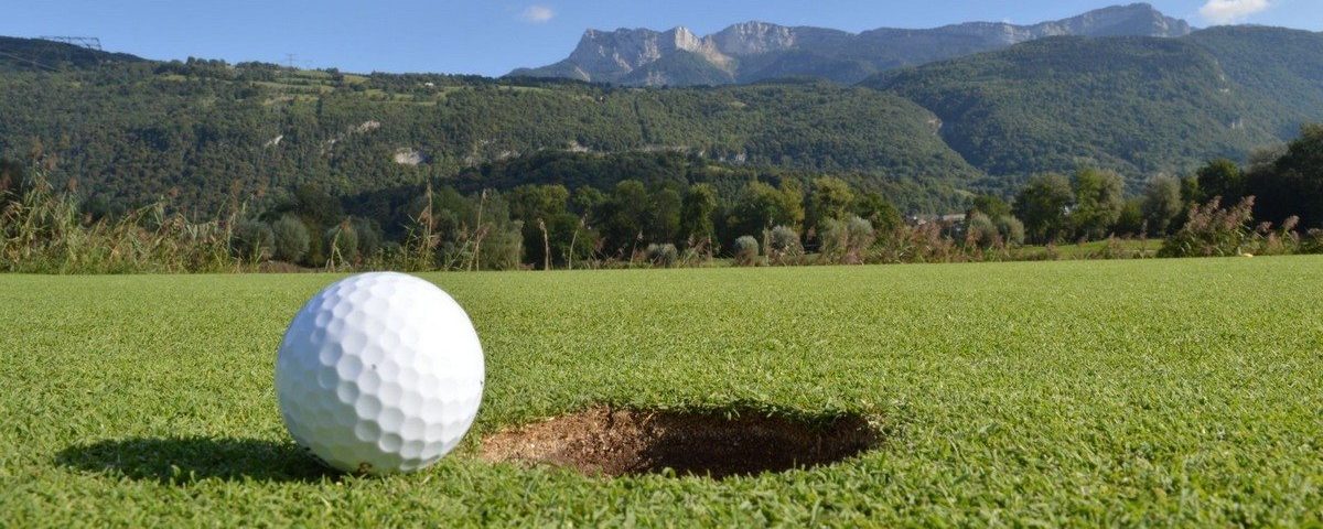 Balle de golf au bord du trou avec en fond une vue sur le Vercors