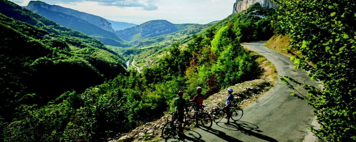 Groupe de cyclistes admirant le paysage sur la route de la Grotte de Choranche dans le Vercors