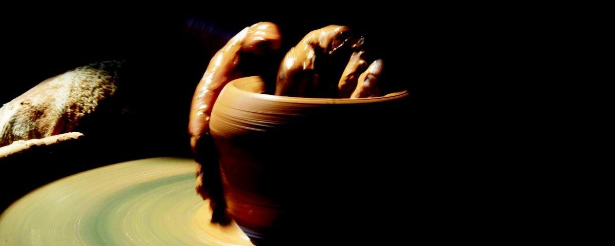 les mains d'un potier fabricant avec de l'argile sur un tour de potier.