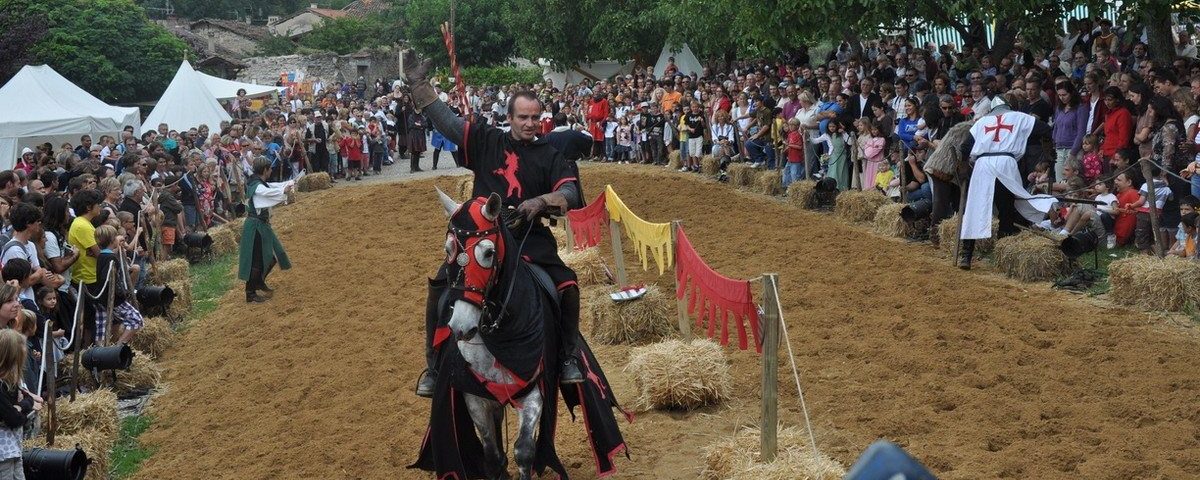 Chevalier sur son cheval saluant la foule pendant les médiévales à Saint-Antoine-l'Abbaye