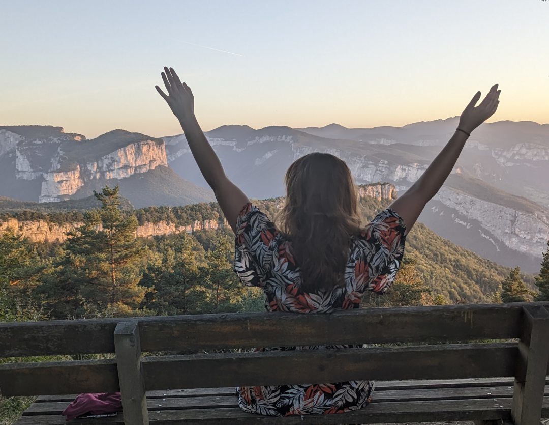 jeune fille les bras au ciel devant panorama des montagnes du vercors à presles