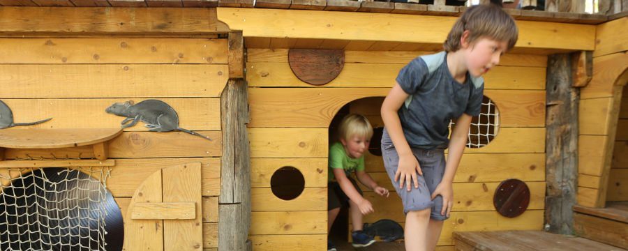 enfants en train de jouer sous un bateau de pirates à saint-antoine-l'abbaye en isère face au vercors