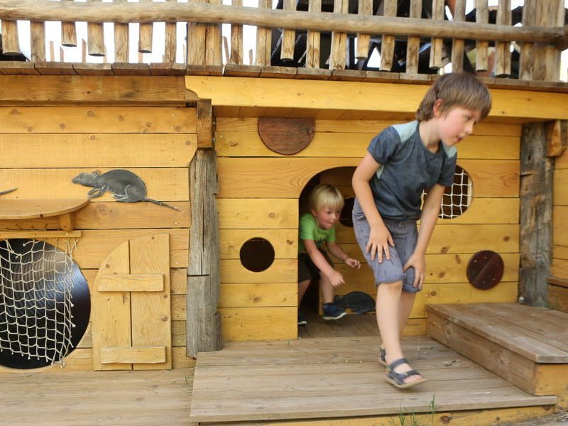 enfants en train de jouer sous un bateau de pirates à saint-antoine-l'abbaye en isère face au vercors