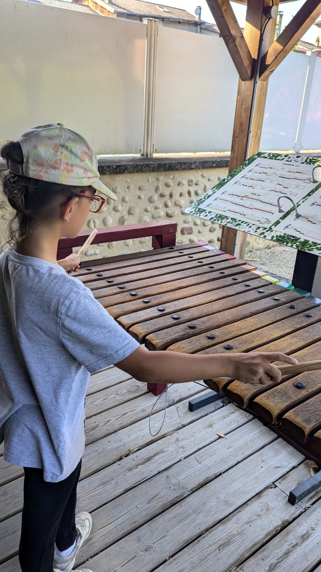 petite fille en train de jouer d'un instrument musical au jardin ferroviaire et musical à chatte