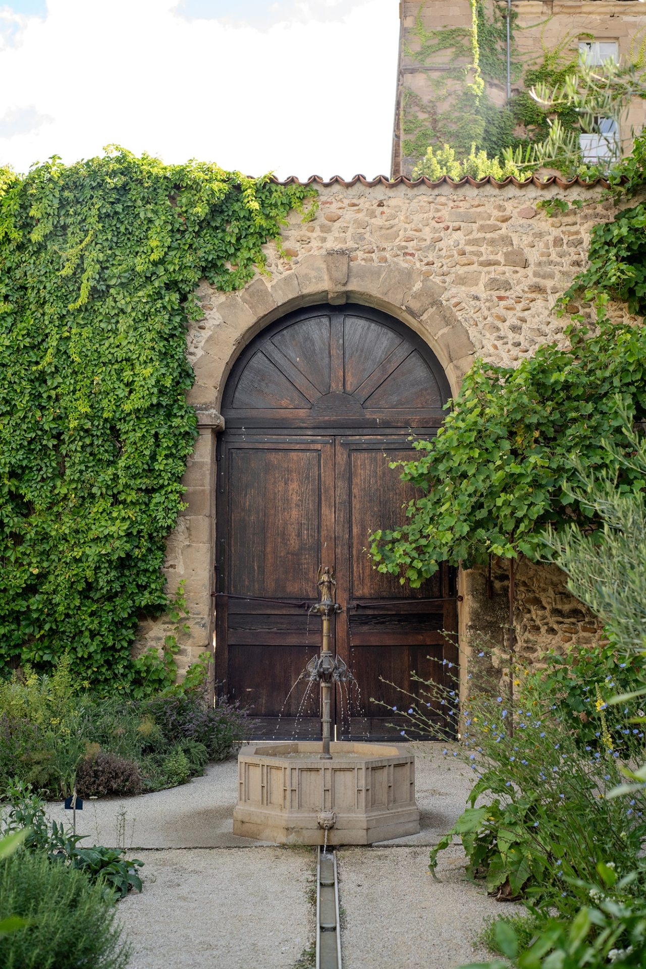 porte et fontaine dans jardin médiéval au musée de saint-antoine-l'abbaye