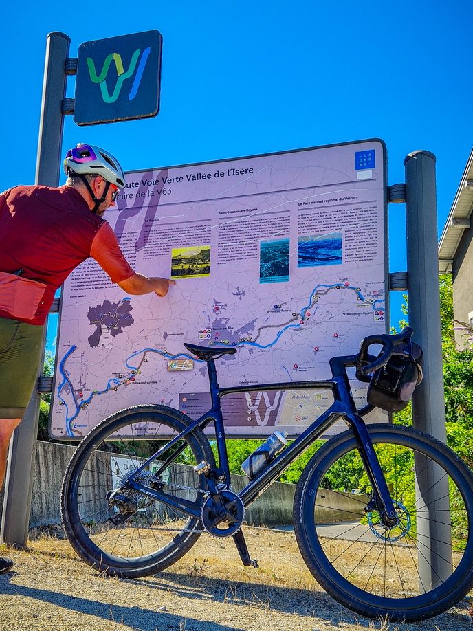 cycliste en train de regarder les panneaux à l'entrée de la belle via