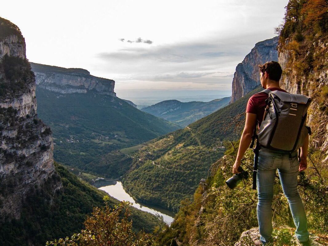Vue panoramique sur les gorges de la Bourne dans le Vercors avec randonneur observant le territoire